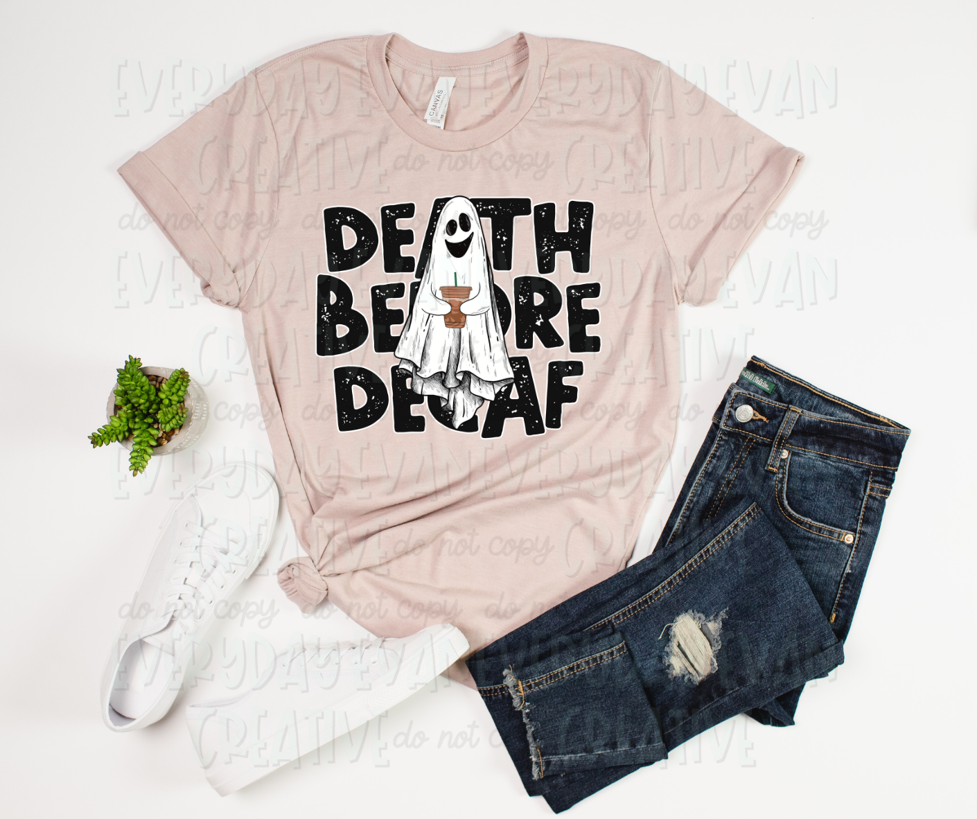 Image displays a t-shirt surrounded by white shoes, a plant, and dark jeans. The shirt's image has creative block font text that reads, "death before decaf." On top of the text, a smiling sheet ghost holds a plastic cup of coffee.