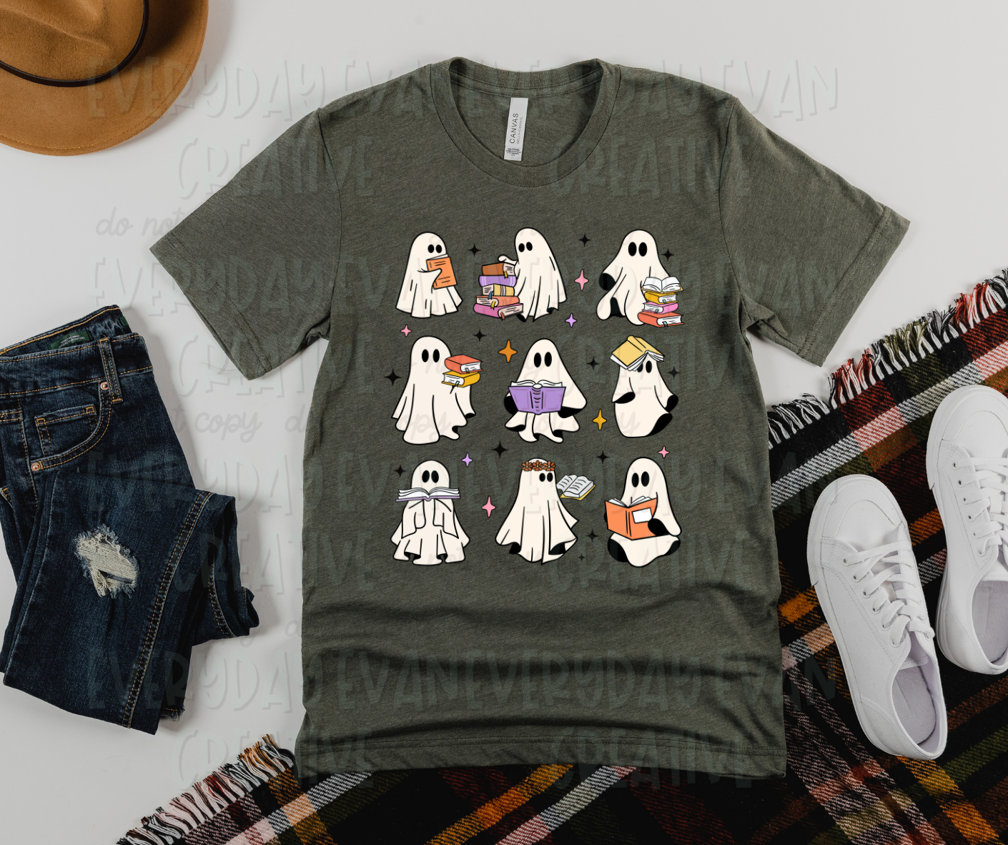 Image displays a dark green t-shirt surrounded by miscellaneous clothing items. The shirt's design includes nine white sheet ghosts in three rows of three. Each ghost has one book or several, all arranged in various fashions, including open, closed, on top of the ghost's head, or in a stack to the side.