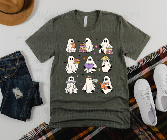 Image displays a dark green t-shirt surrounded by miscellaneous clothing items. The shirt's design includes nine white sheet ghosts in three rows of three. Each ghost has one book or several, all arranged in various fashions, including open, closed, on top of the ghost's head, or in a stack to the side.