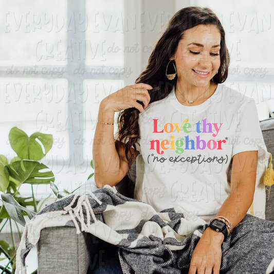A brunette white woman sits on a couch modeling a white t-shirt. The design on the shirt says "Love thy neighbor" in rainbow text. There is a gray asterisk following neighbor. In parentheses it says "no exceptions" in gray cursive text. 